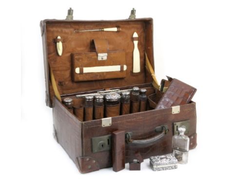 Late Victorian gentleman's crocodile skin fitted vanity case, having a incomplete complement of seven silver mounted bottles,