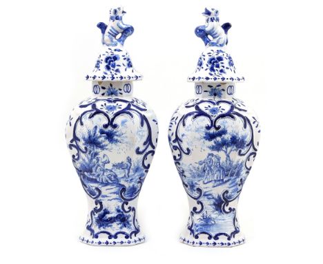 Pair of Dutch delft lidded vases in 18th Century style, each having a domed cover surmounted with a lion finial over an octag