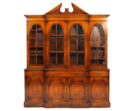 Quality burr walnut breakfront library bookcase in the Georgian style, late 20th Century, having a broken architectural pedim