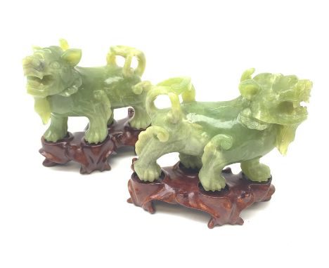 A pair of carved jade dogs of fo, each upon shaped wooden stand, figures H9.5cm.  - Condition Report 