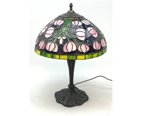 A Tiffany style table lamp, with cast spreading base detailed with flowers, and leaded glass shade, overall H53cm. - Conditio