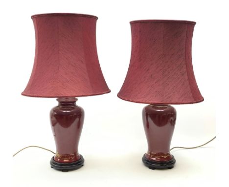 A pair of burgundy ceramic lamps, of baluster form, with matching burgundy shades, overall H71cm.  - Condition Report 