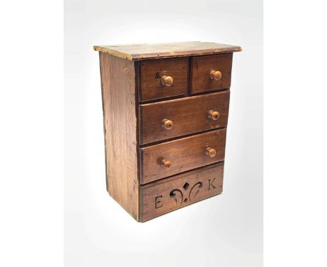 A Victorian pine miniature straight front chest of two short and two long drawers, the platform base pierced with the initial