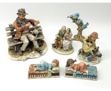 A selection of Capodimonte figures, comprising a large figure group modelled as a tramp on a bench with dog, a smaller group 