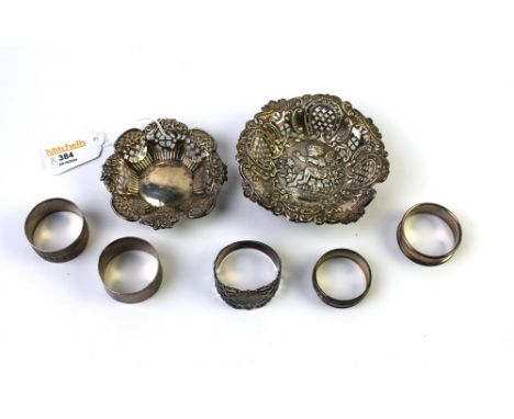 Two silver decorated pin dishes, two silver napkin rings and three plated napkin rings 