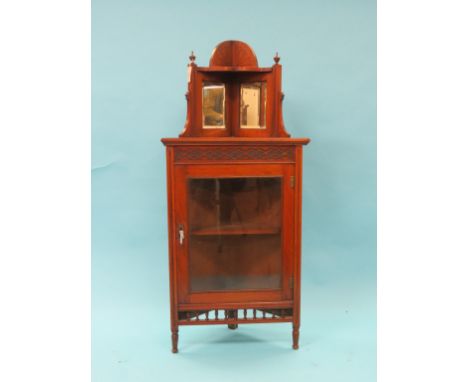 A late Victorian walnut corner-fitting display cabinet, mirrored over-shelf above blind-fret frieze, single glazed door, 2ft.