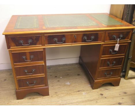 A reproduction yew-veneered desk, inset gilt-tooled leather top with three drawers, three further drawers to each pedestal, b