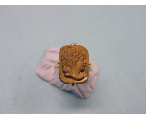 An 18ct. gold tiger's-eye dress ring, stone finely-carved with a portrait bust, elaborate head-dress, size H