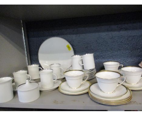 Four late 20th century Royal Worcester teacups, saucers and tea plates, having a white ground with gilt borders, together wit