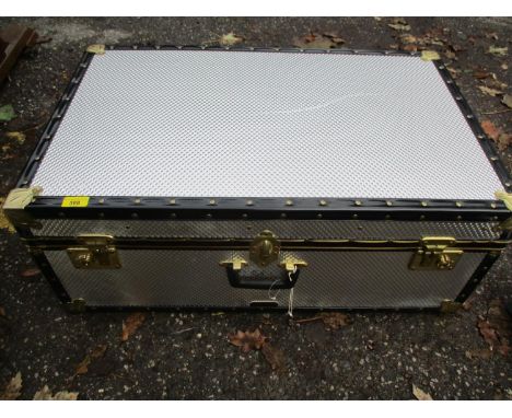 A modern chrome effect trunk with brass hardware 