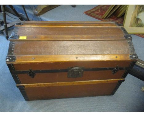 A vintage canvas and metal bound twin handled domed top trunk 
