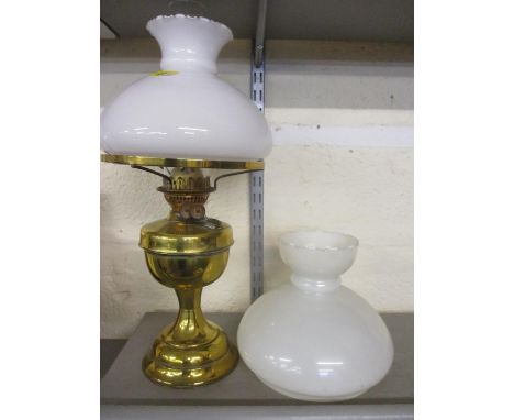 A Victorian brass oil lamp with milk glass shade and glass funnel, together with another shade 