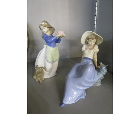 Nao figurines to include a young girl holding a cake away from a dog by her feet, and a reclining woman looking towards a bir