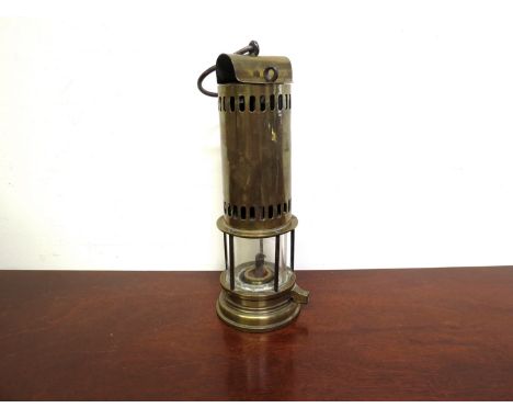 A brass miner's lamp, removable lid with split pin and removable bonnet ventilation holes at top and bottom, unusual