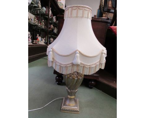 A gilt and silvered lamp base with wrythen style form together with a cream tasselled shade