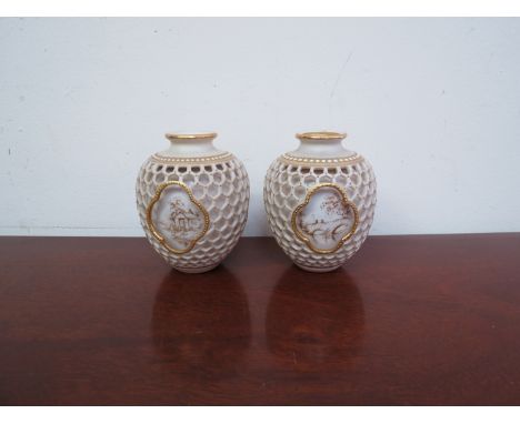 A matched pair of Royal Worcester late 19th Century/early 20th Century reticulated vases by George Owen, pierced with a wide 