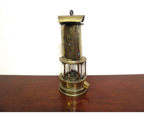 An E.Thomas brass miner's lamp with gauze protected by a brass shield, hinged lid (stamped with a crest)