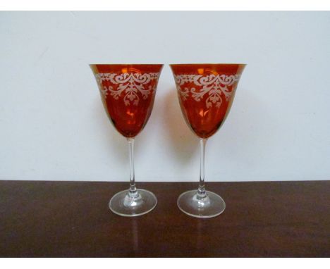 A set of eight etched ruby coloured wine glasses