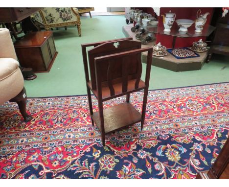 In the manner of "Liberty & Co." an Arts and Crafts oak two division Canterbury with wavy slat decoration over an under shelf