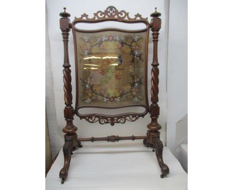 A Victorian rosewood firescreen with fretworked ornament, a tapestry panel of a peacock in a fruiting branch, set in a frame,