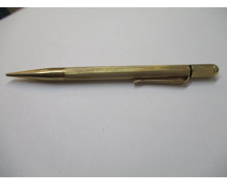 A 9ct rose gold cased propelling pencil with engine turned ornament and a rotating top 