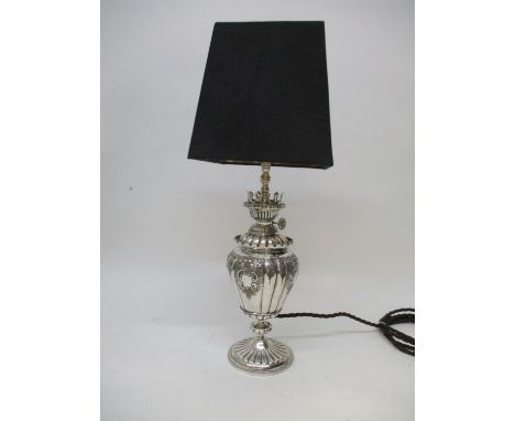 A late Victorian silver plated Britannia metal oil lamp, converted to electricity, of vase design on a splayed, reeded foot r