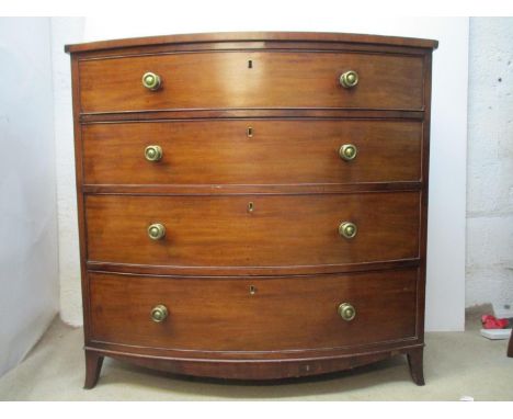 An early 19th century mahogany, bow fronted chest with a secretaire drawer, over three graduated long drawers, on splayed bra