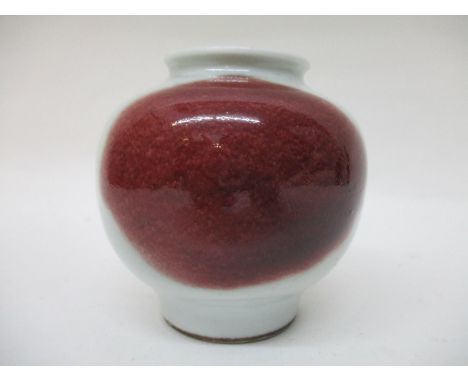 An 18th century Chinese vase of bulbous form with a wasted neck and tapered foot, in blue/white ground with a patch of mottle