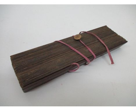 A 19th century South East Asian Buddhist manuscript on palm leaves, with wooden covers, 11 1/2" l 