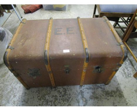 A leather bound travelling trunk having twin carrying handles 
