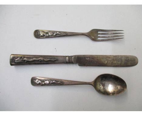 A Chinese silver three piece christening set comprising a knife, a fork and a spoon, each decorated with a dragon and initial