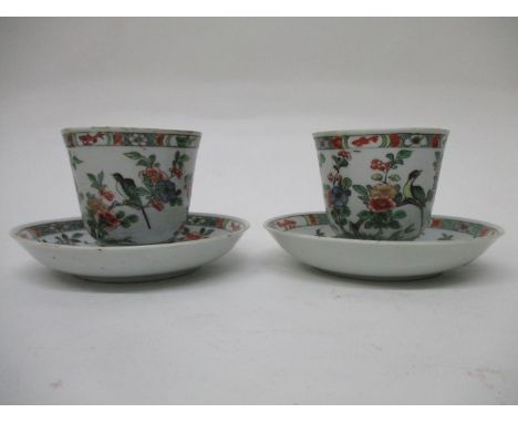 A pair of early 18th century famille vert cups and saucers with a bell shaped cup, on a foot rim and deep saucer with an inte