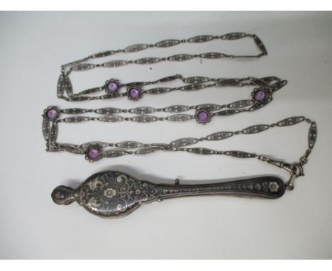 A late 19th/early 20th century Niello lorgnettes decorated with scrolls, swags and masks, activated by a sprung catch, on a f