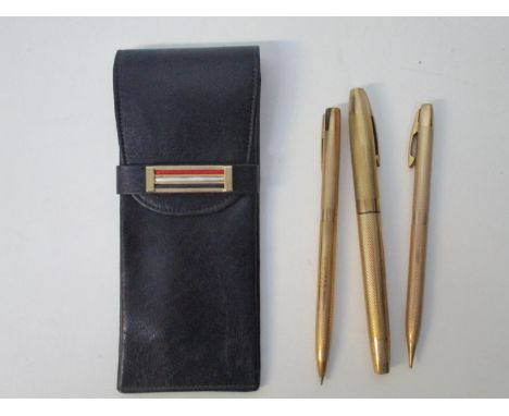 A set of three Shaffer 9ct gold cased pens with engine turned ornament, comprising a fountain pen, a ballpoint pen and a prop