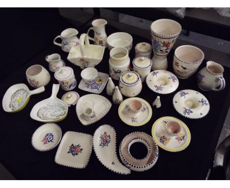 A large collection of Poole pottery to include egg cups, preserve jars, jugs, trinket dishes and similar