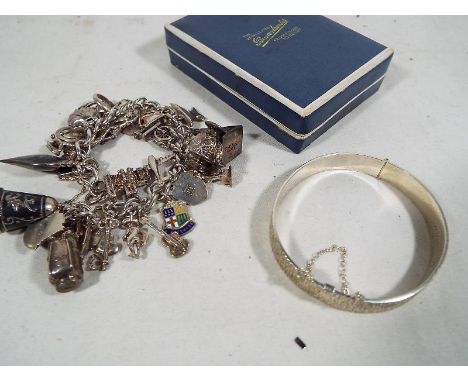 A silver charm bracelet, approximate weight 78 grams and a hallmarked silver bangle, approximate weight 22 grams