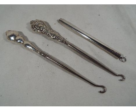 Two hallmarked silver button hooks and a silver thermometer case, various assay marks