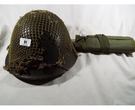 A British Army post-war combat helmet with lining and camouflage netting and weapon tool belt