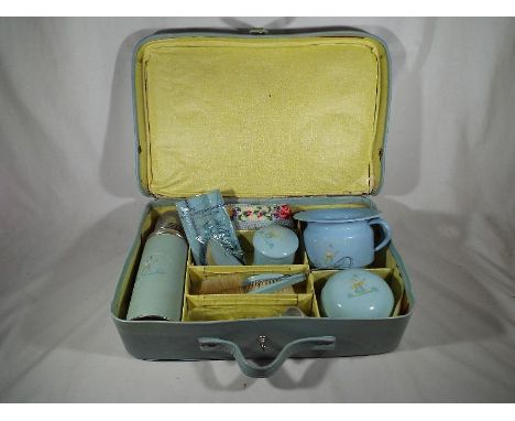 A vintage powder blue suitcase marked patent no. 358920 containing a baby's first items to include a vacuum flask, a ceramic 