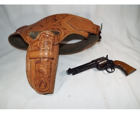 A replica Colt 45 re-enactment blank firing pistol together with an fine tooled highly decorated light brown leather gun hols