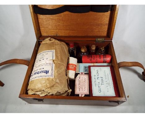 An early to mid 20th century mahogany cased First Aid box with contents, much of which unused and marked T & W & W Southall, 