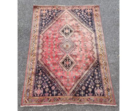 A large tribal carpet, having three central medallions, with geometric borders, 302 x 211cm.