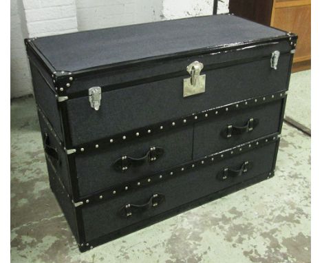TRUNK, grey and black studded with a rectangular rising top enclosing space for storage over two short and one long drawer, 1