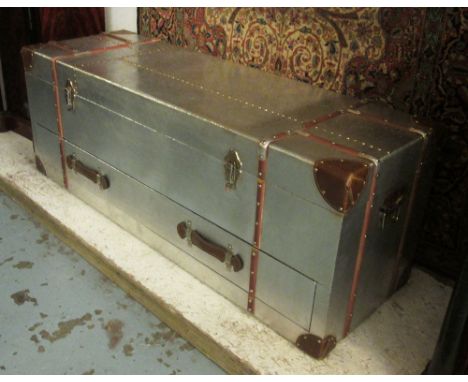 AVIATOR STYLE LOW TRUNK, with a rectangular rising top enclosing space for storage, a carrying handle to each side and a long