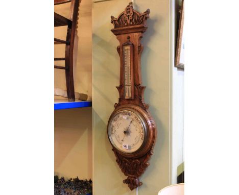 Carved oak aneroid barometer with enamelled dial