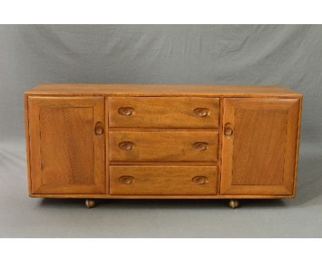 AN ERCOL GOLDEN DAWN ELM SIDEBOARD, flanked by three drawers central to two cupboard doors on orbit castors, approximate size