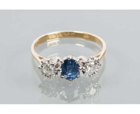 SAPPHIRE AND DIAMOND THREE STONE RING
set with a central oval cut sapphire of approximately 0.65 carats, flanked by illusion 