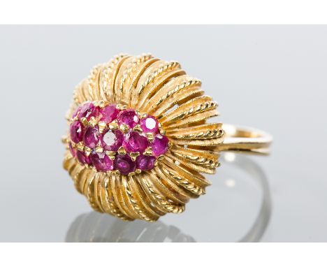 UNUSUAL EIGHTEEN CARAT GOLD RUBY DRESS RING
the oval bezel set with a cluster of brilliant cut rubies, in a pierced setting, 