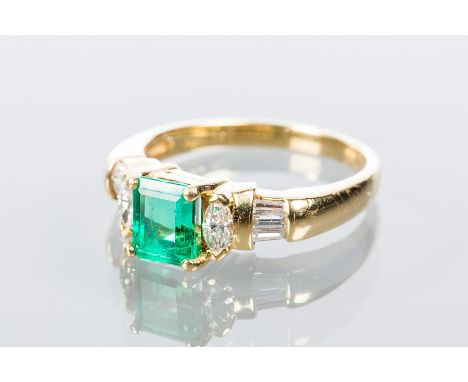 EMERALD AND DIAMOND RING
set with a step cut emerald of approximately 1.0 carats, between two brilliant cut diamonds on each 