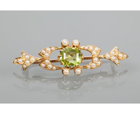 EDWARDIAN PERIDOT AND SEED PEARL BROOCH
of stylised foliate design, with a central step cut peridot between clusters of split